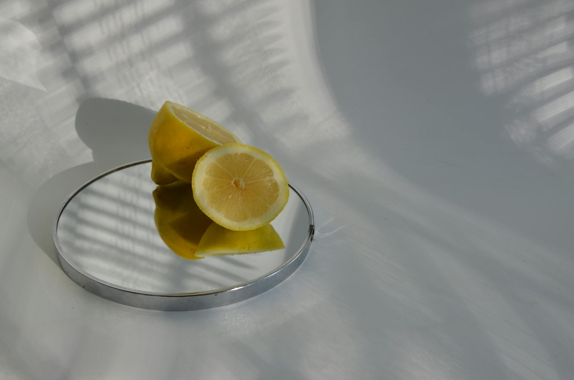 A yellow silicone vibrator surrounded by fresh fruit on a bright yellow background
