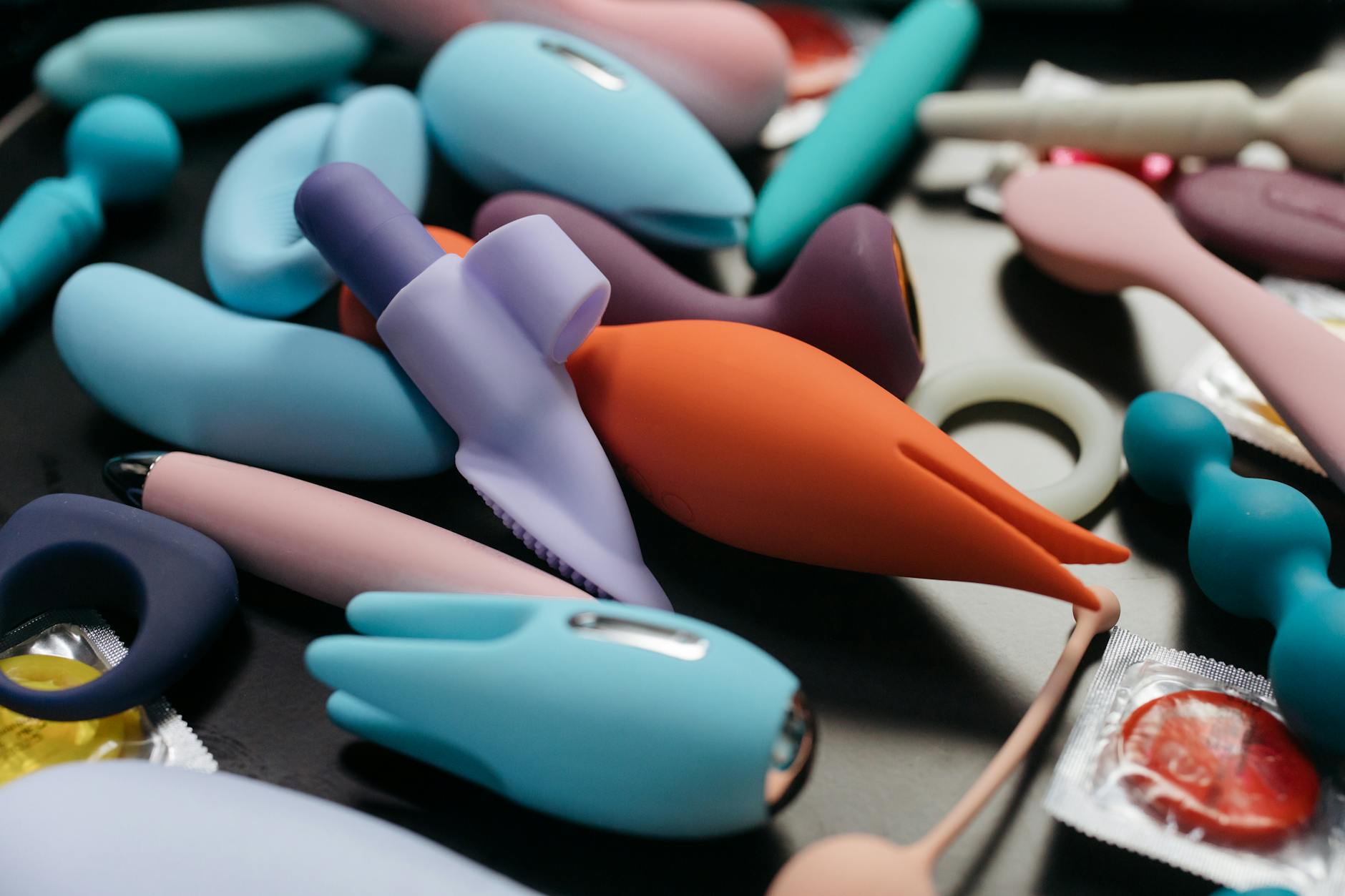 Array of vibrant adult toys including clitoral vibrators and massage tools