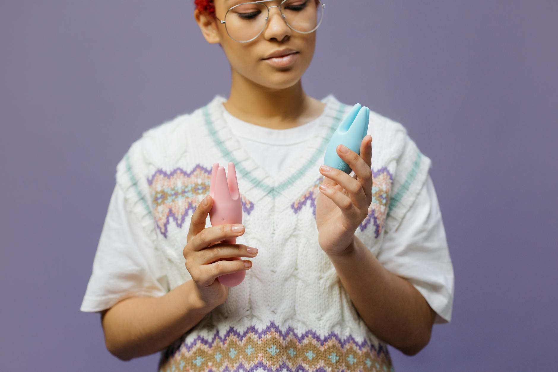 青とピンクのシリコンバイブレーターを持つ眼鏡をかけた女性