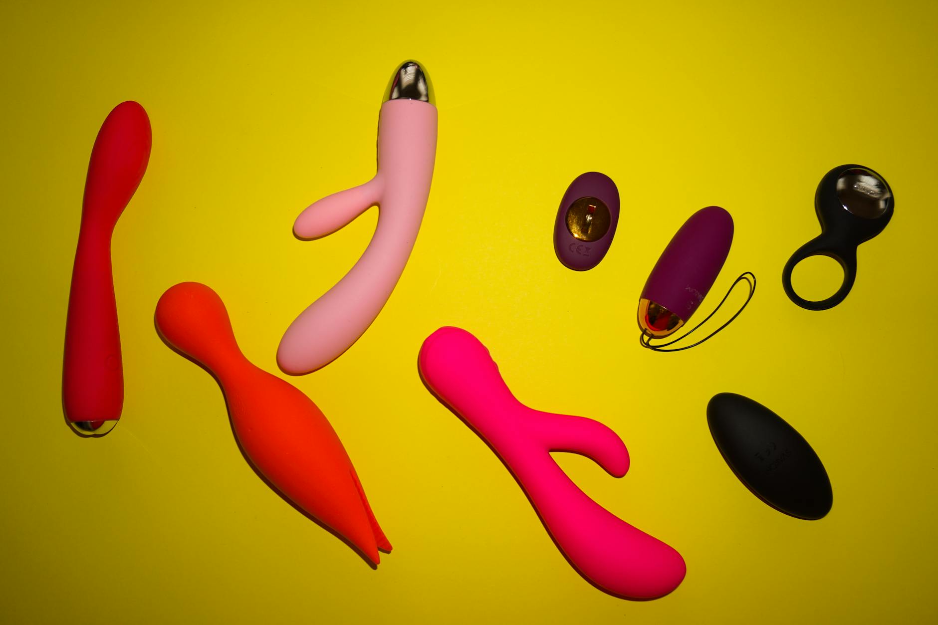A hand holding a vibrator against a minimalist purple backdrop, representing intentional pleasure without pressure