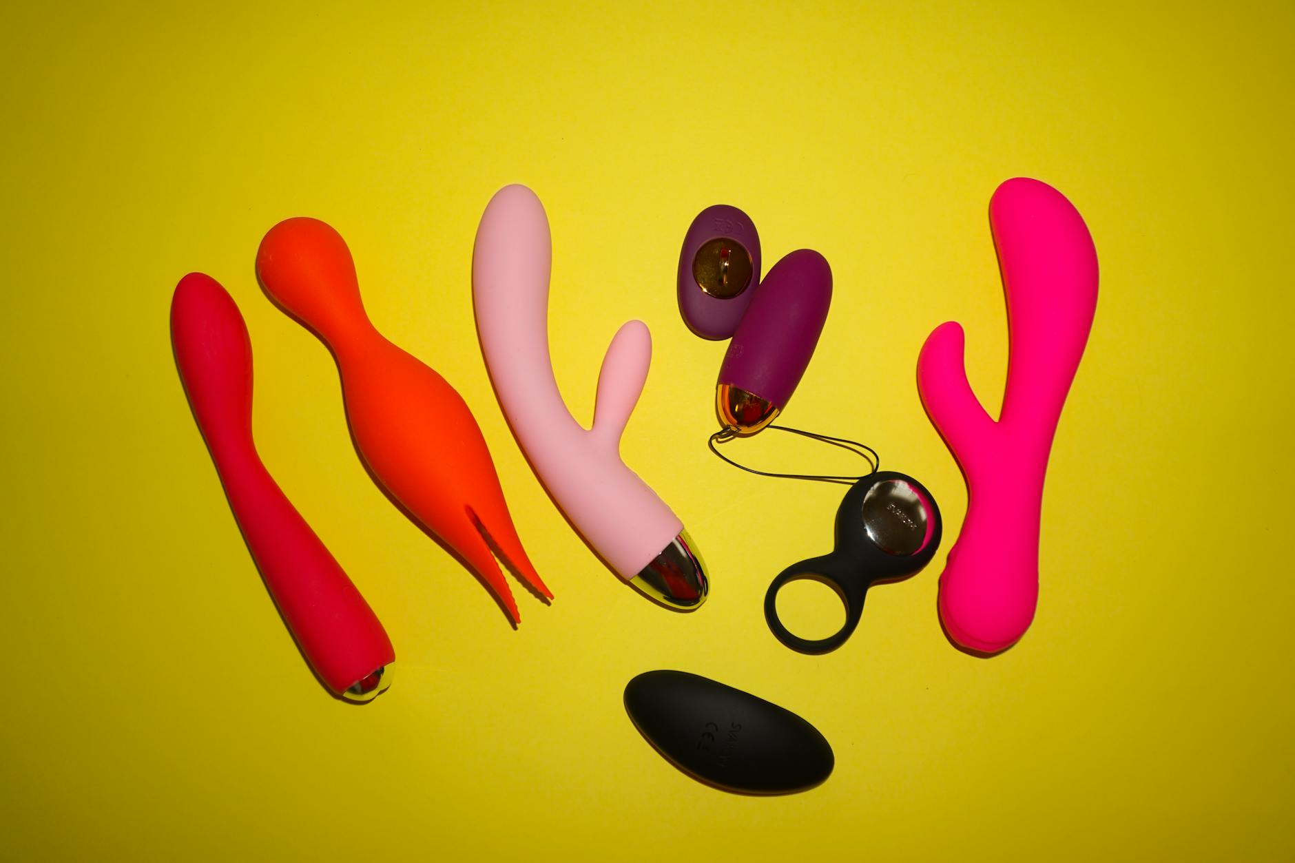 Two people holding clitoral vibrators together in a thoughtful moment