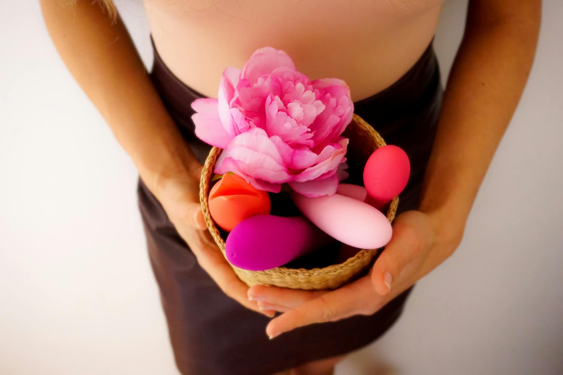 Blue vibrator surrounded by flowers and citrus slices on yellow background