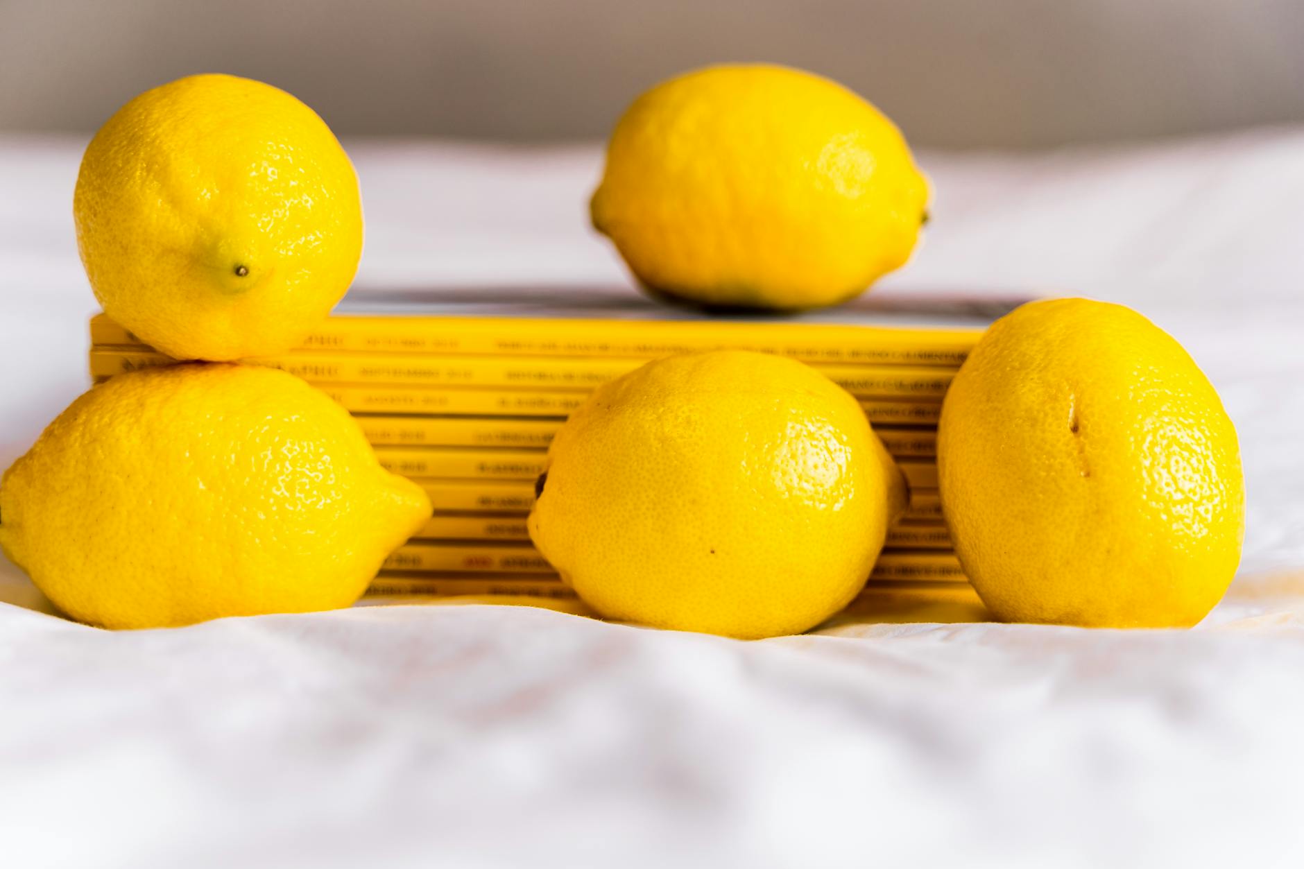 Vivid yellow lemons arranged on a bright yellow background, representing renewal and freshness